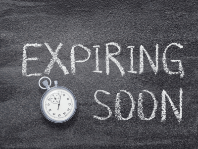 Is Your Tech About to Expire? Stopwatch beside the words "Expiring Soon" written in chalk, symbolizing outdated technology approaching end-of-service.