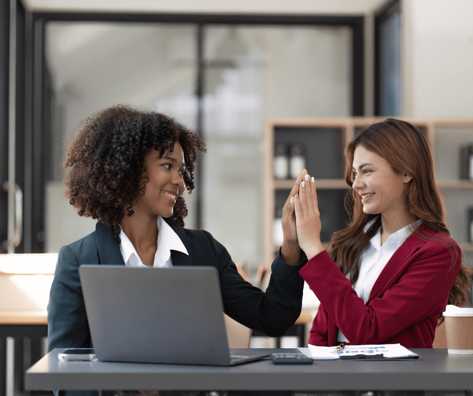 Two happy employees high fiving after getting a job done Two happy employees high fiving after getting a job done